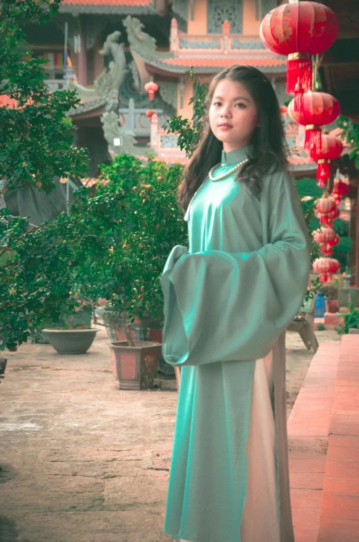 a woman standing on the pavement in front of chinese lanterns