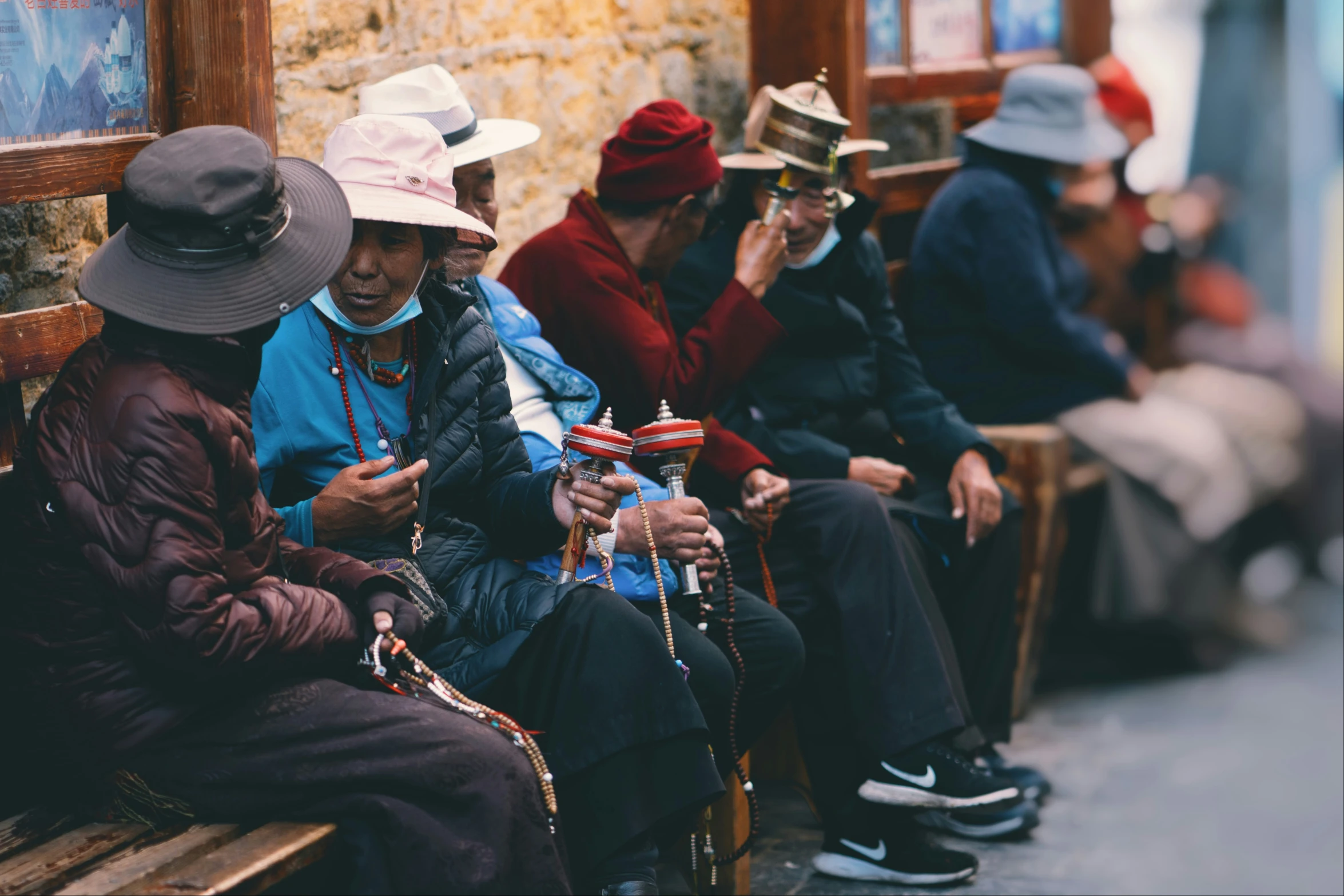 people sitting in line looking at their cell phones