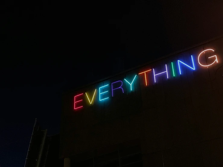 the word everything is lit up in neon colored lights