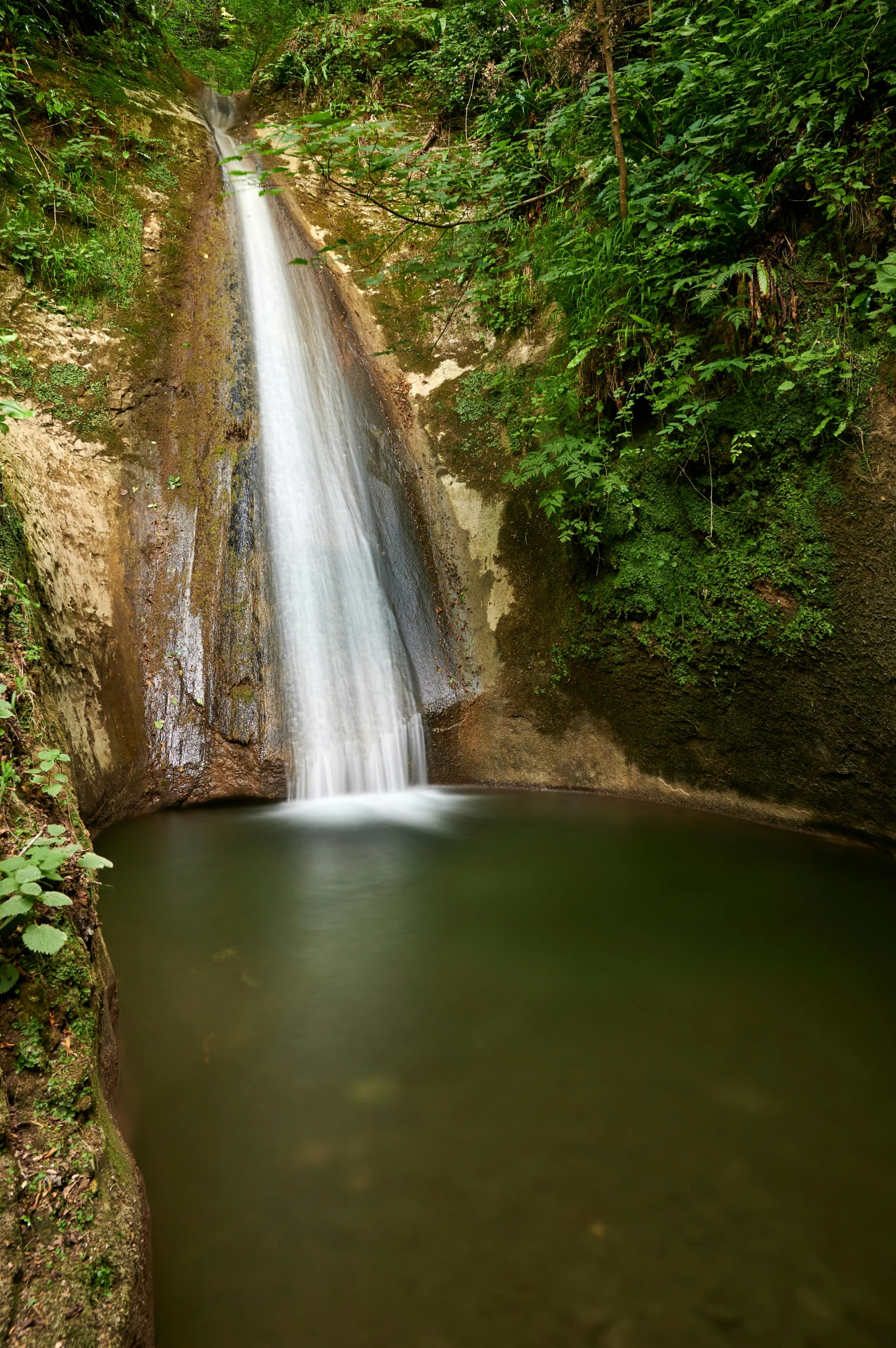 a small waterfall with water running out the side of it