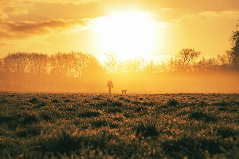 a person standing on a grassy field under a cloudy sky