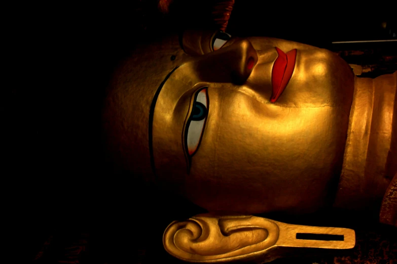 a close up view of a statue at night with gold colored clothing