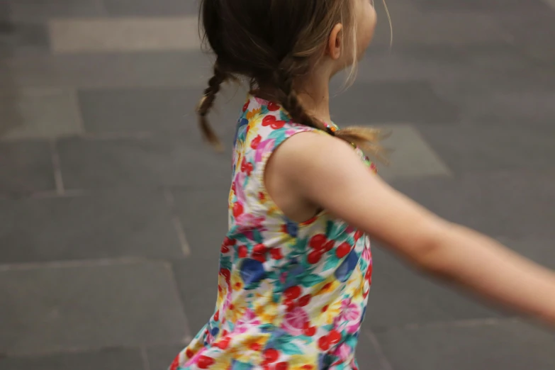 a little girl in a dress that is holding a frisbee