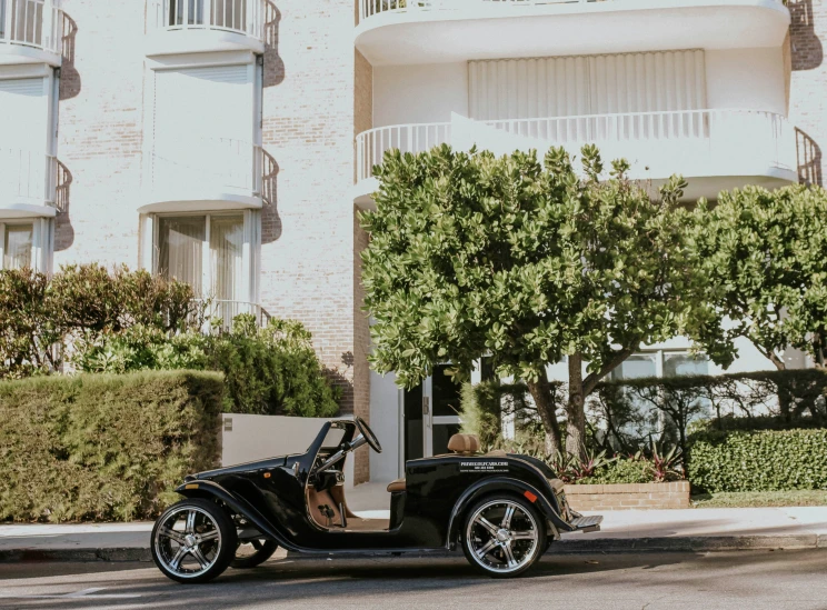 a black classic motorcycle is parked in front of an apartment building