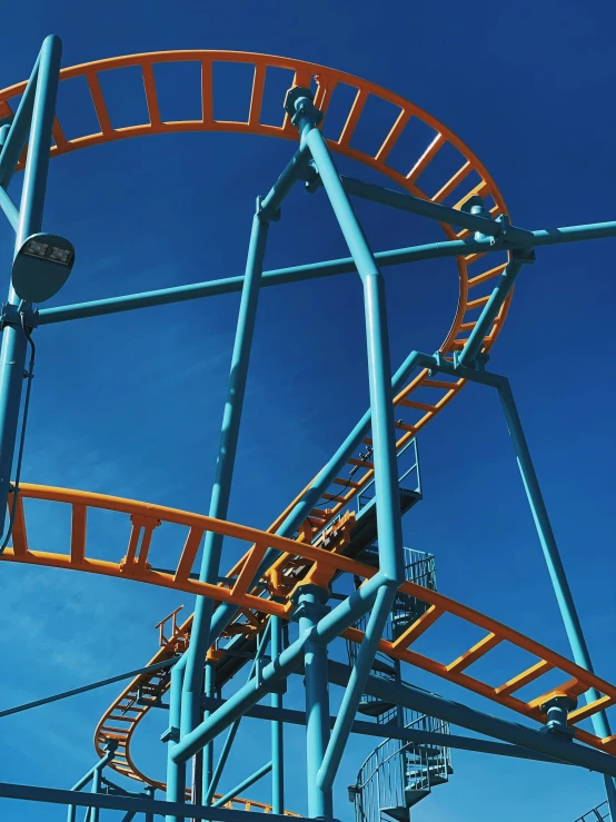 an orange roller coaster ride on a bright day