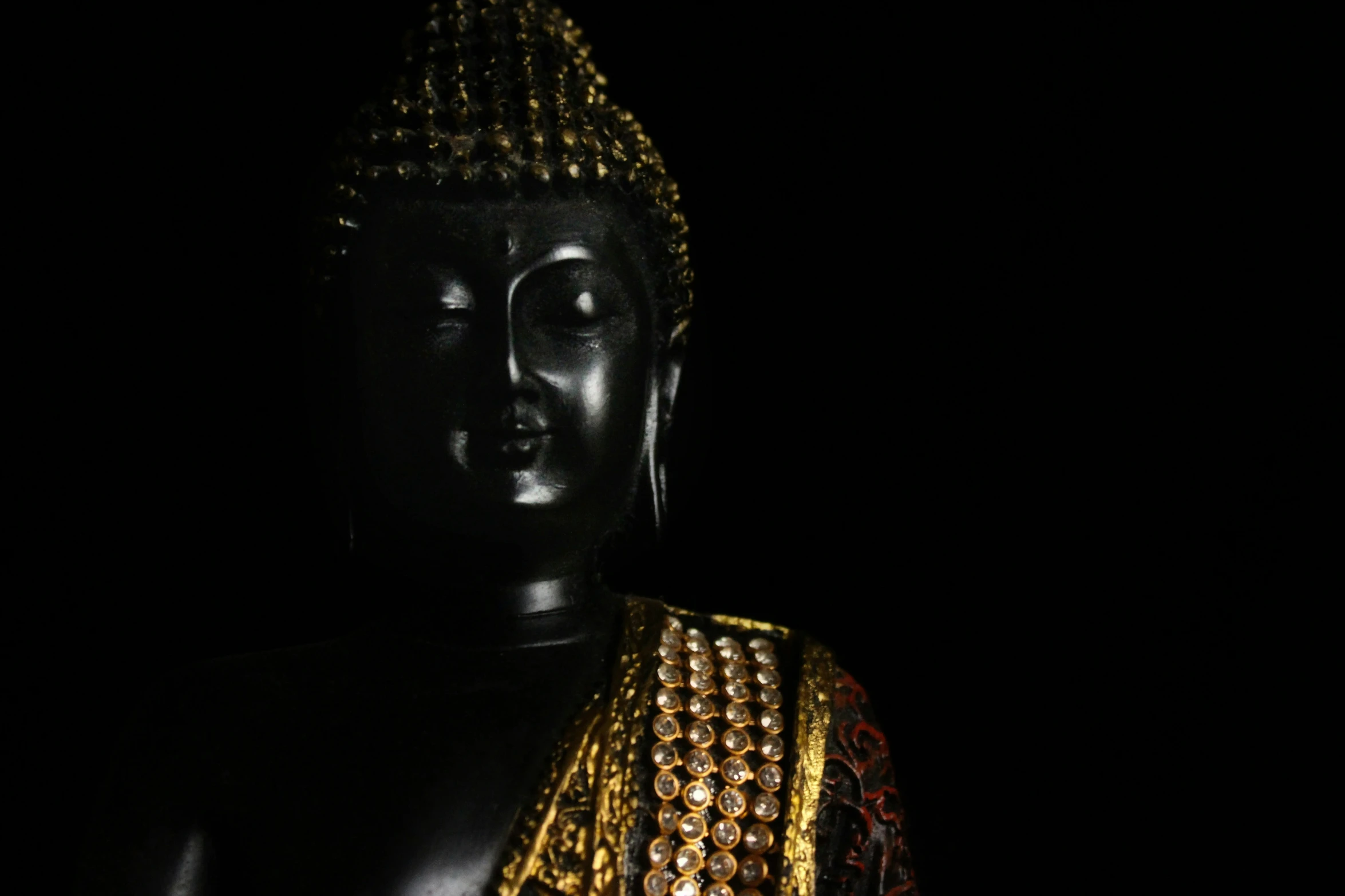 the buddha statue is wearing some beaded jewelry