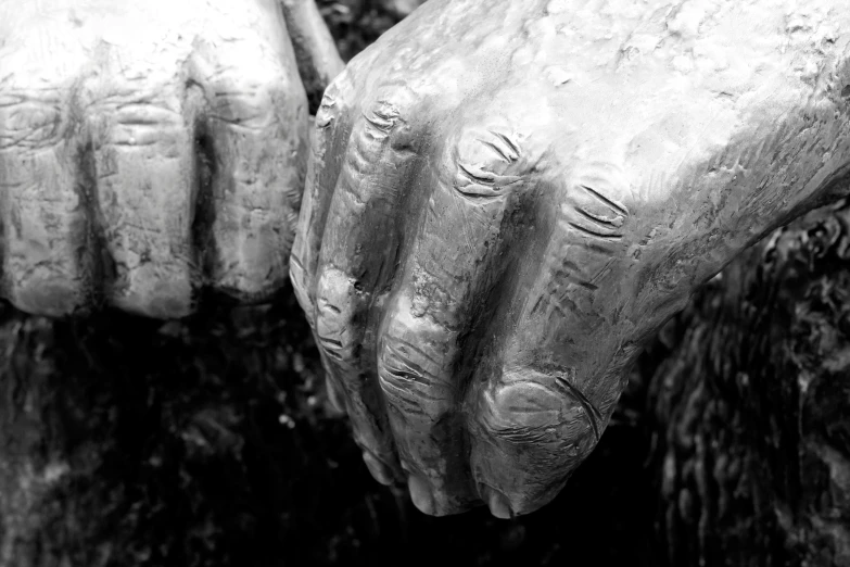a close up of a statue with hands reaching for soing