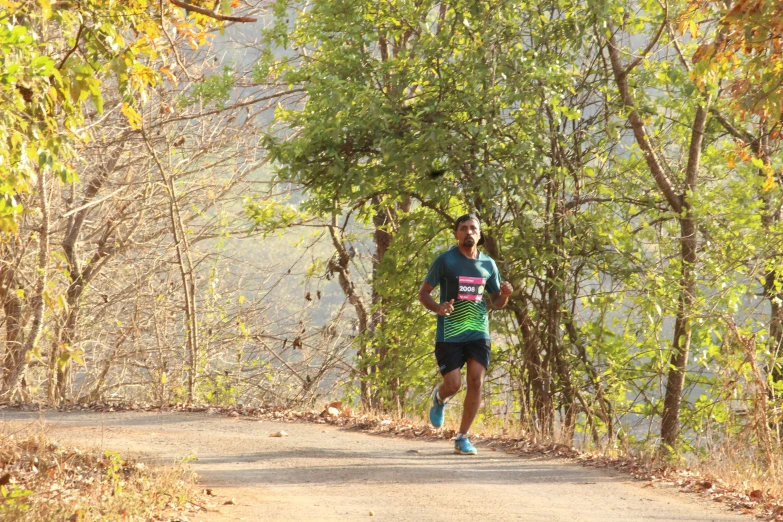 a man running along a dirt road near trees