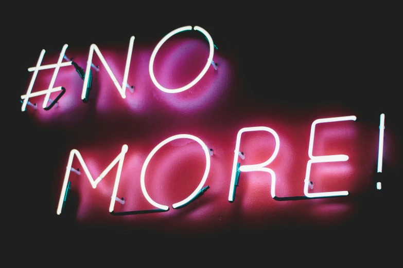 a neon sign that says no more on the side of a building