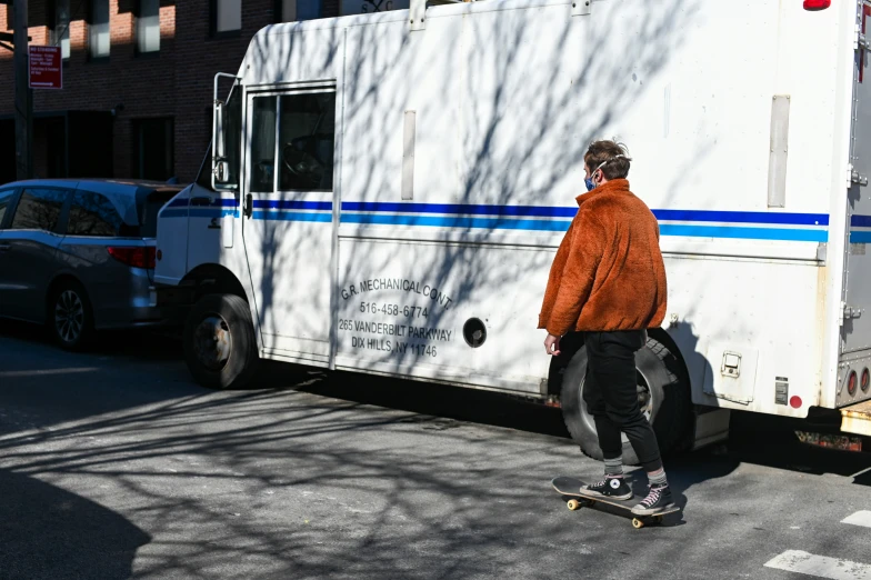 a skateboarder in a red jacket riding a skateboard on the street