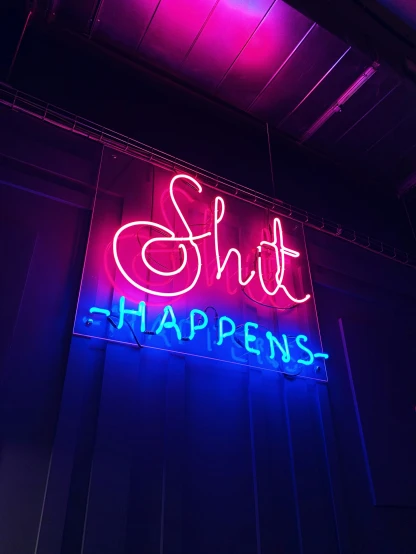 neon sign displayed against the wall reading s happens