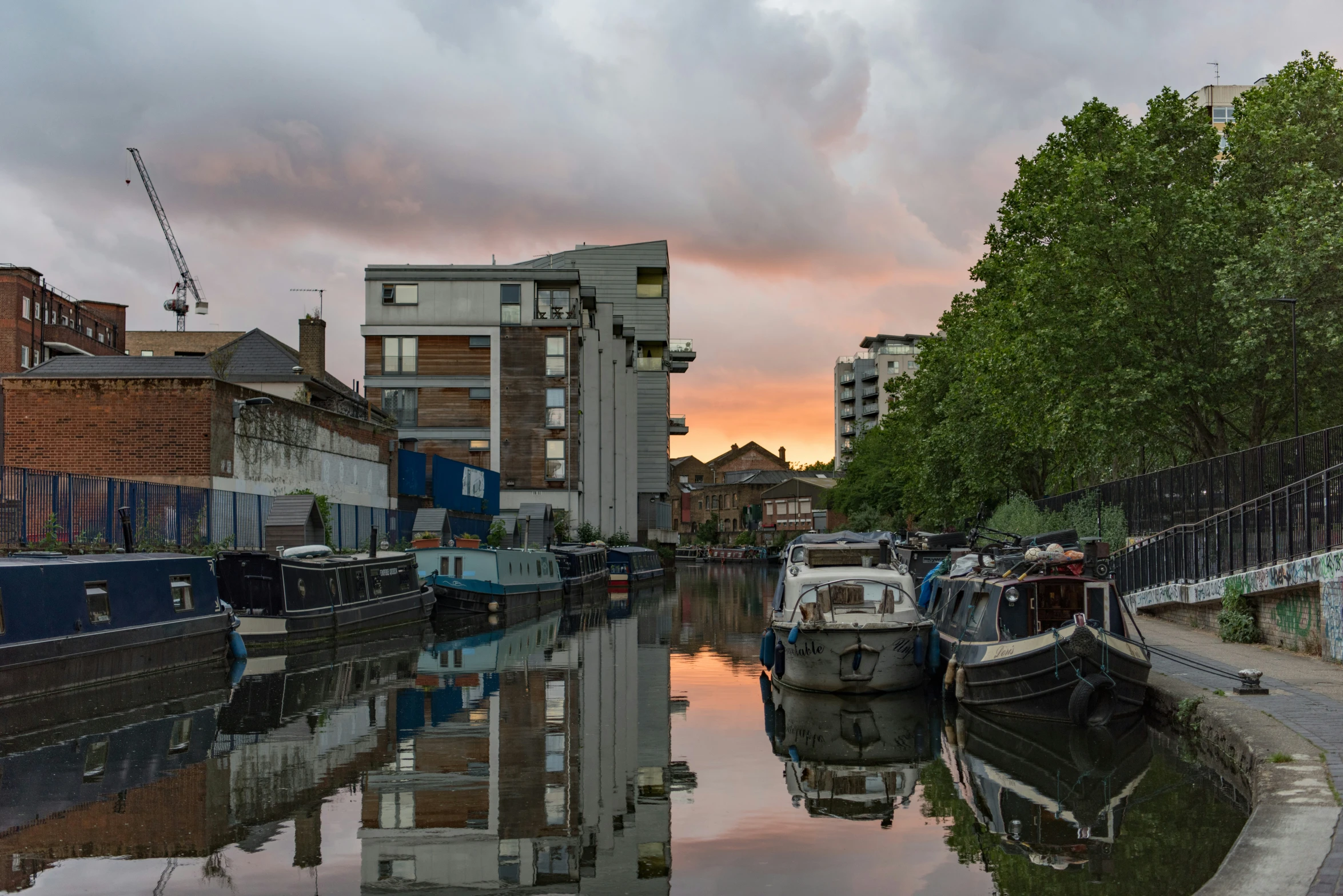 a row of boats in the water next to a street