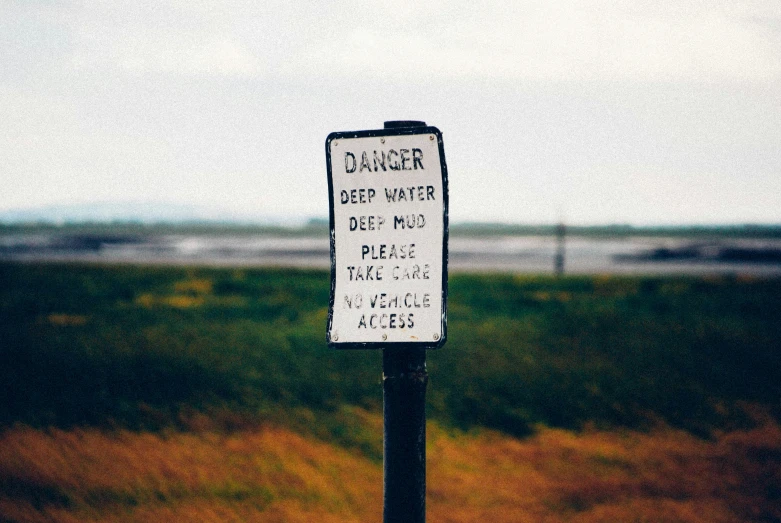 a warning sign is posted in an empty field