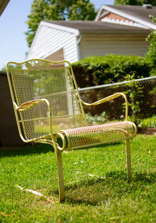 an iron bench is sitting in the grass