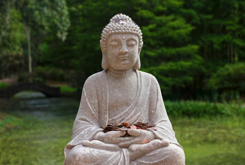 a large statue is in the grass by some trees