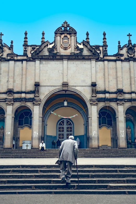 two people walking on a stone stairway in front of a building