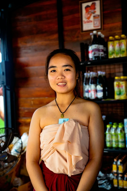 a young woman in a dress standing near a bar