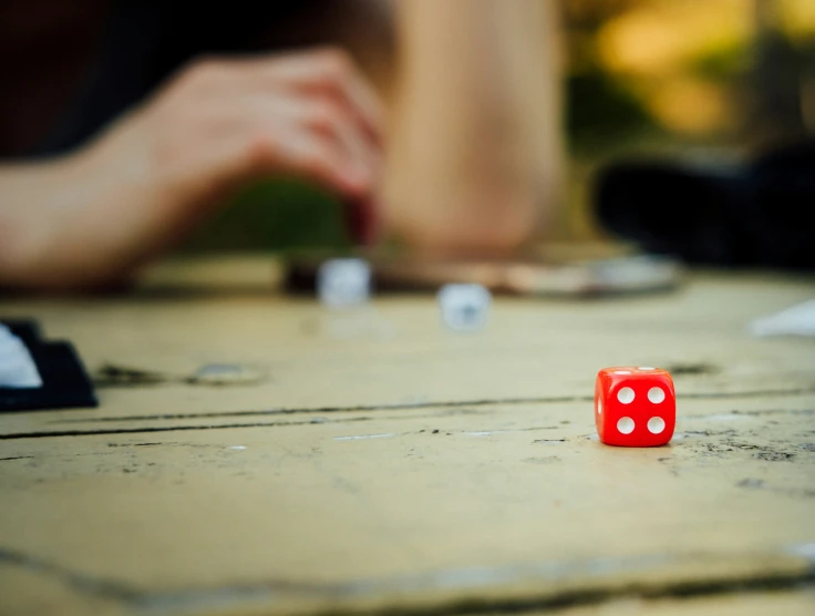the red dice is sitting on the wooden table