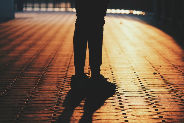 a man is standing in the street with his shadow