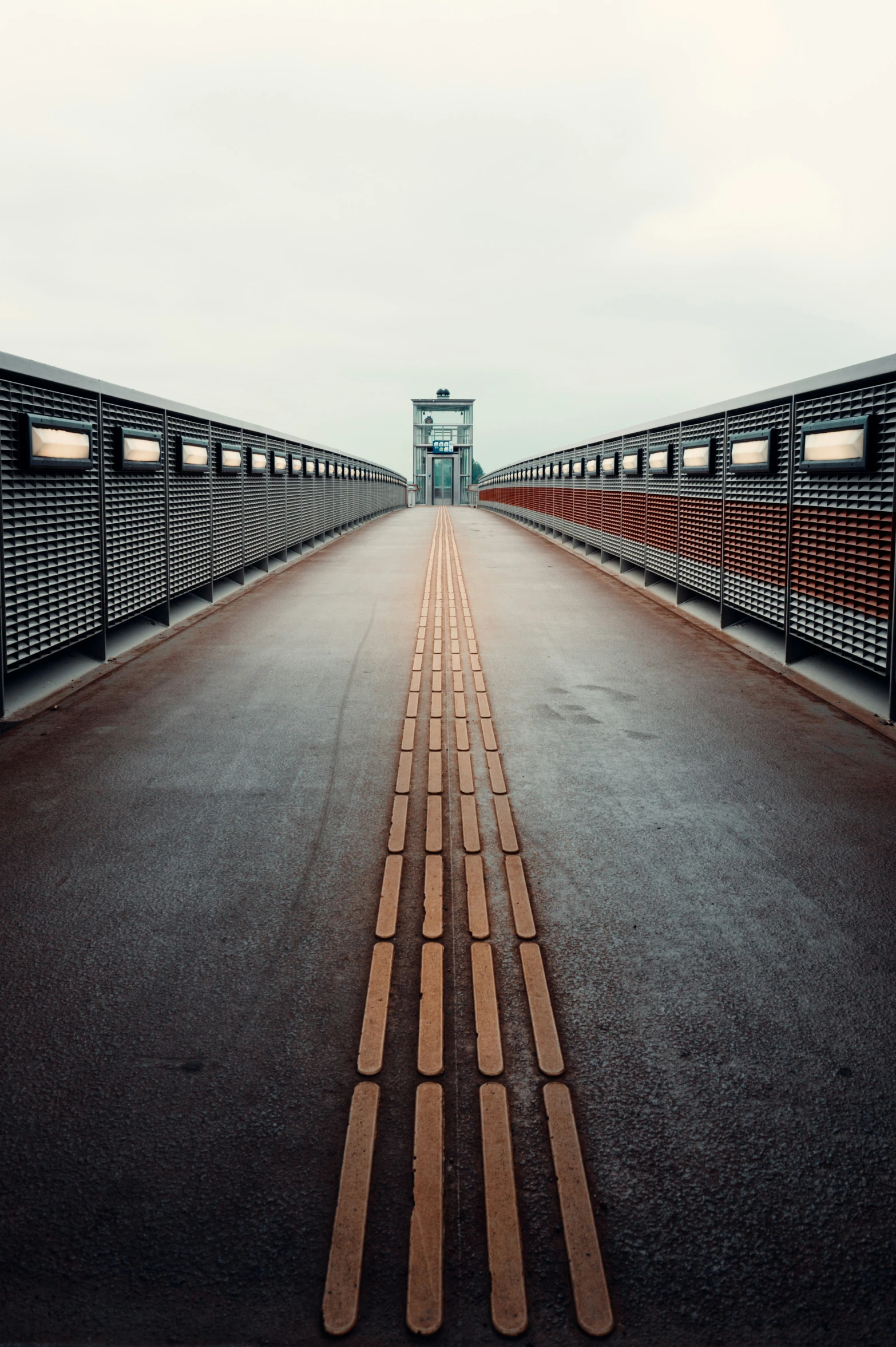 an empty bridge crossing a road into a city