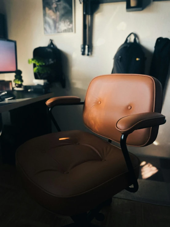 a leather desk chair in front of a computer screen