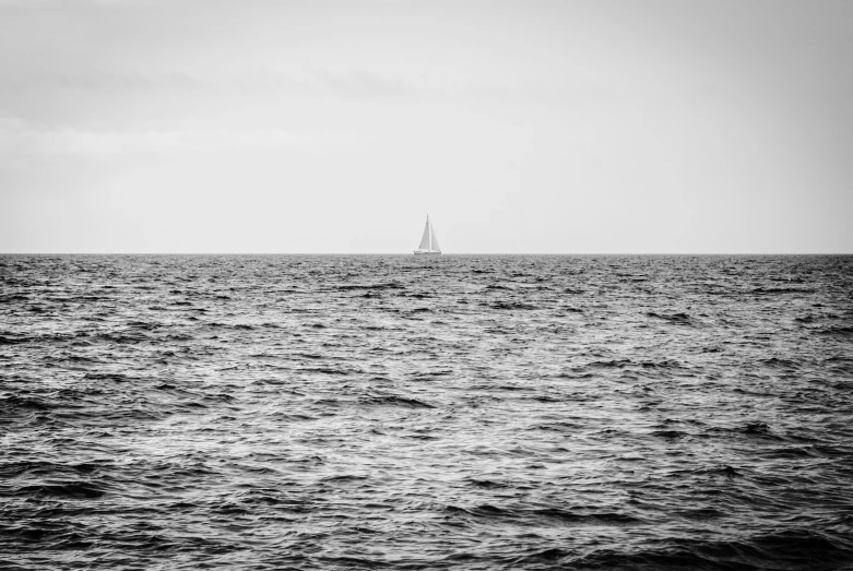 a lone sailboat floating across the ocean