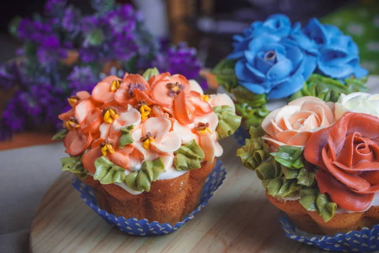 two cakes with flowers sitting on top of each other