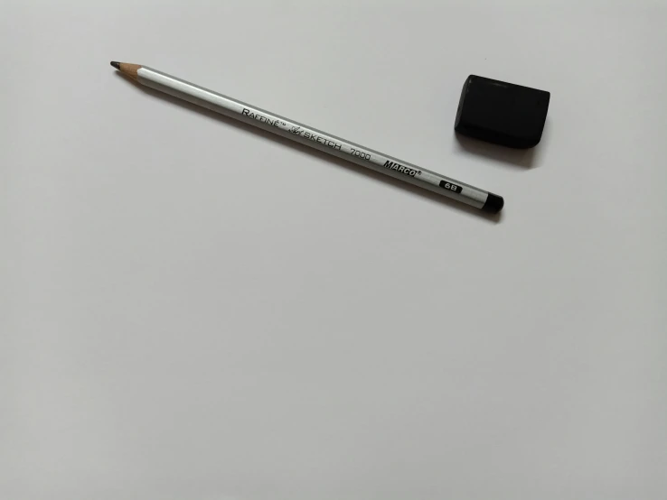 a white surface with a pen and a rubber pad