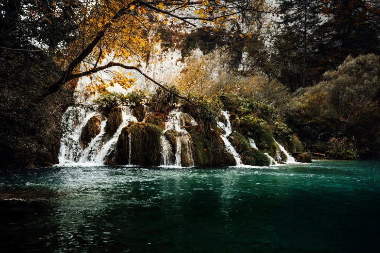 a group of water fall cascading down into the water