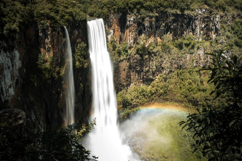 a rainbow is on the waterfall and the water was almost clear