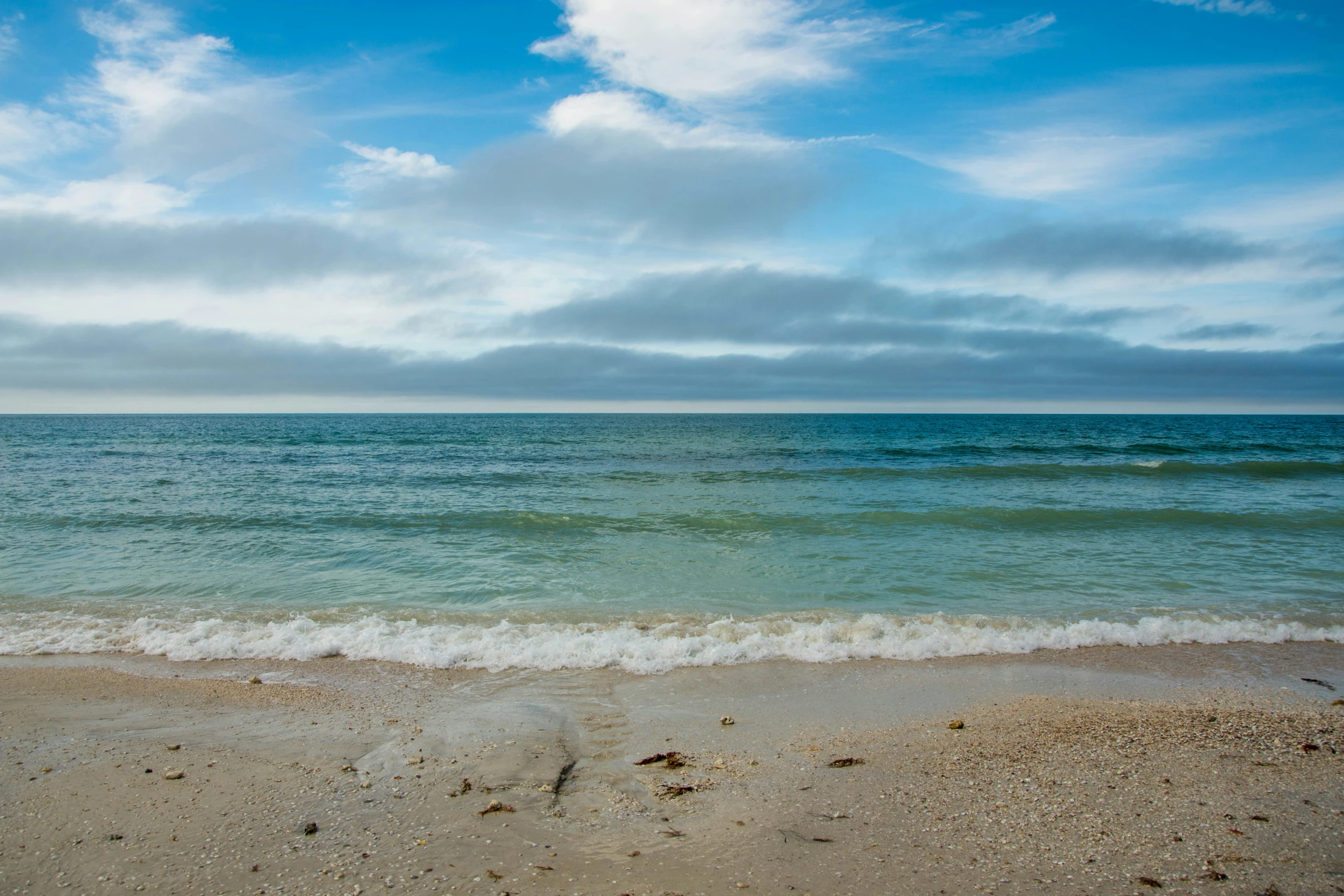 an ocean view with a lone white surf board and no waves