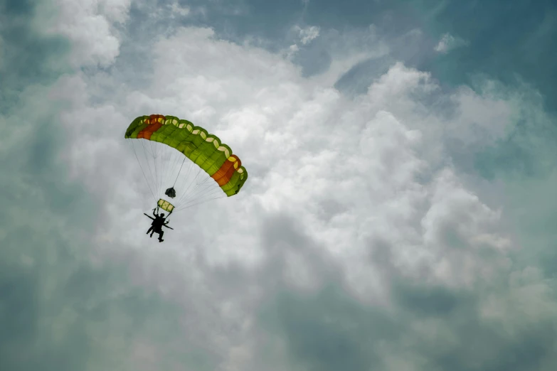 someone paragliding high in the air with one parachute on