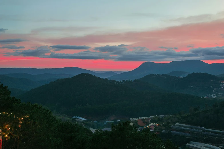 pink sky above a green valley with mountains