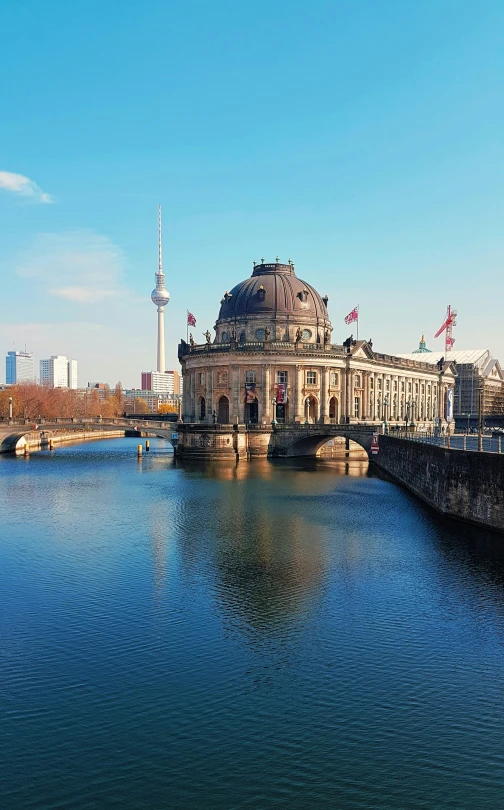 an image of a river scene with buildings and a bridge