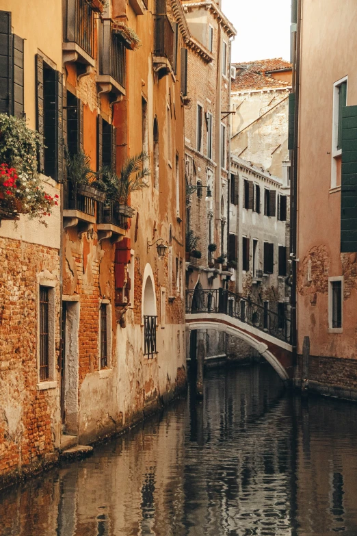 an alleyway with boats traveling along side of buildings