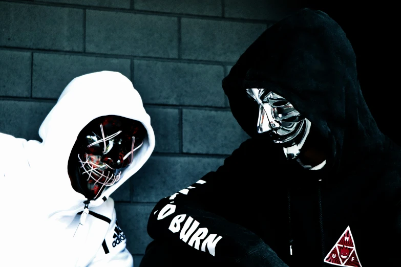 two people dressed in white and wearing masks and hoods