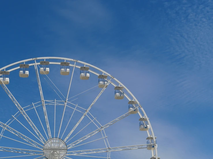 a ferris wheel with the sun out behind it