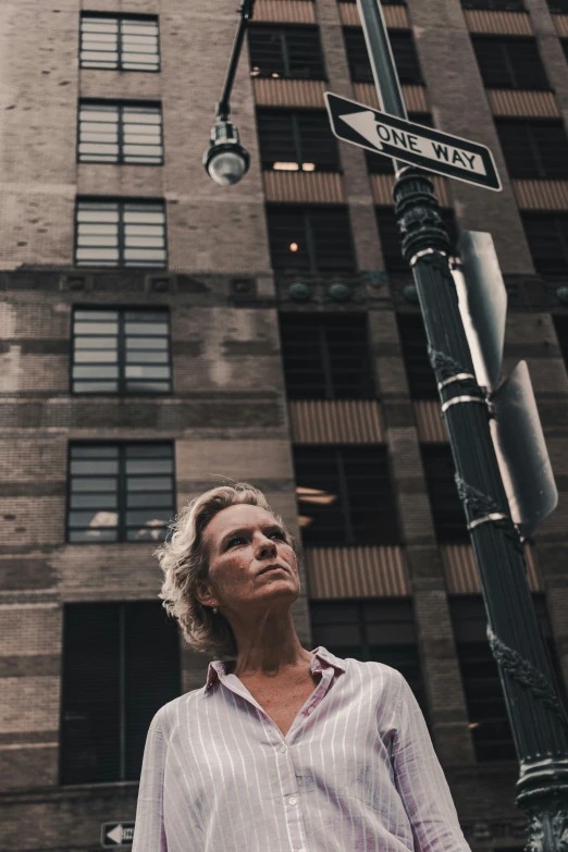 a man stands by the road sign for one way