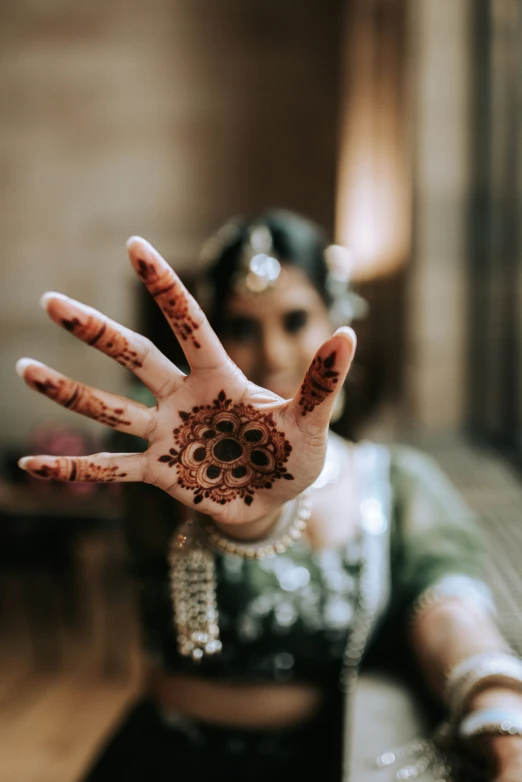 a woman has her hands out showing off hendi designs