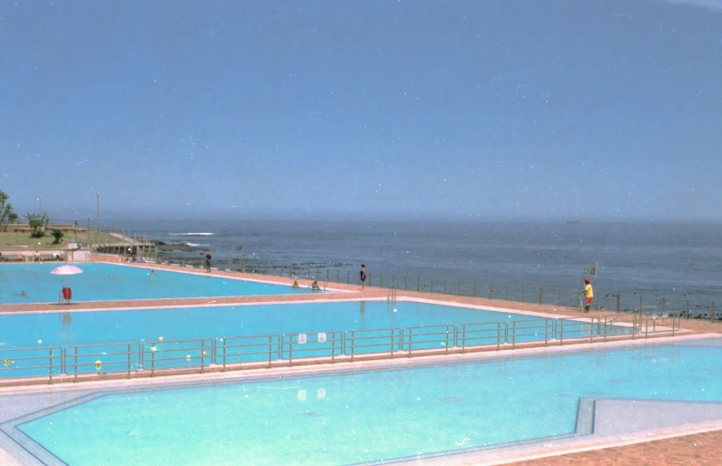 a large swimming pool next to an ocean