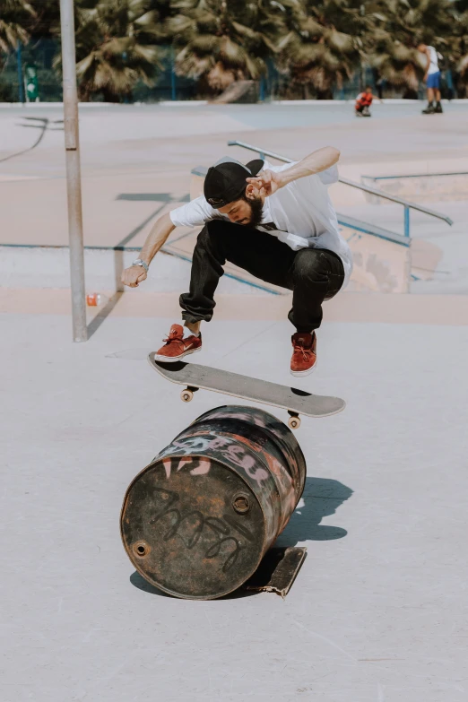 a skateboarder riding over barrels with his skate board