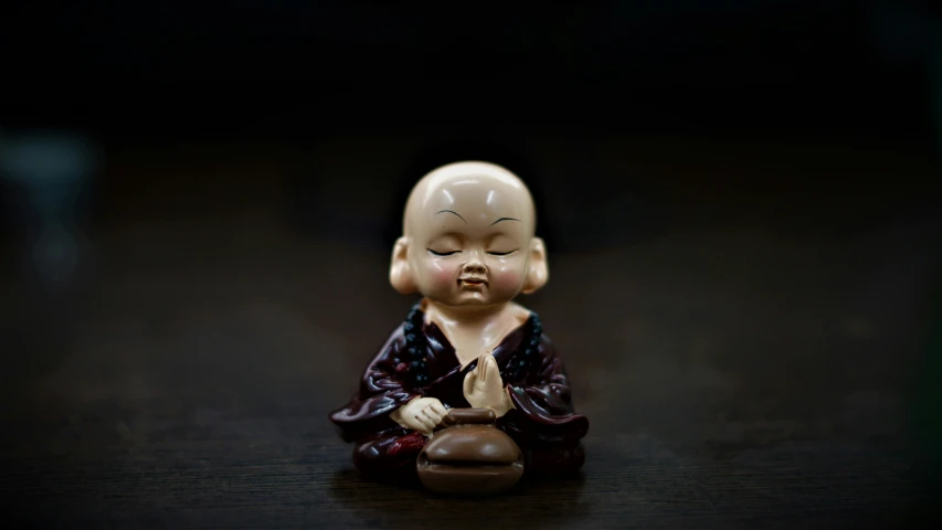 a buddha figurine sitting on a black surface