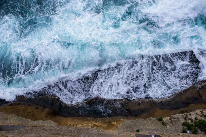 the waves and the beach are crashing against each other