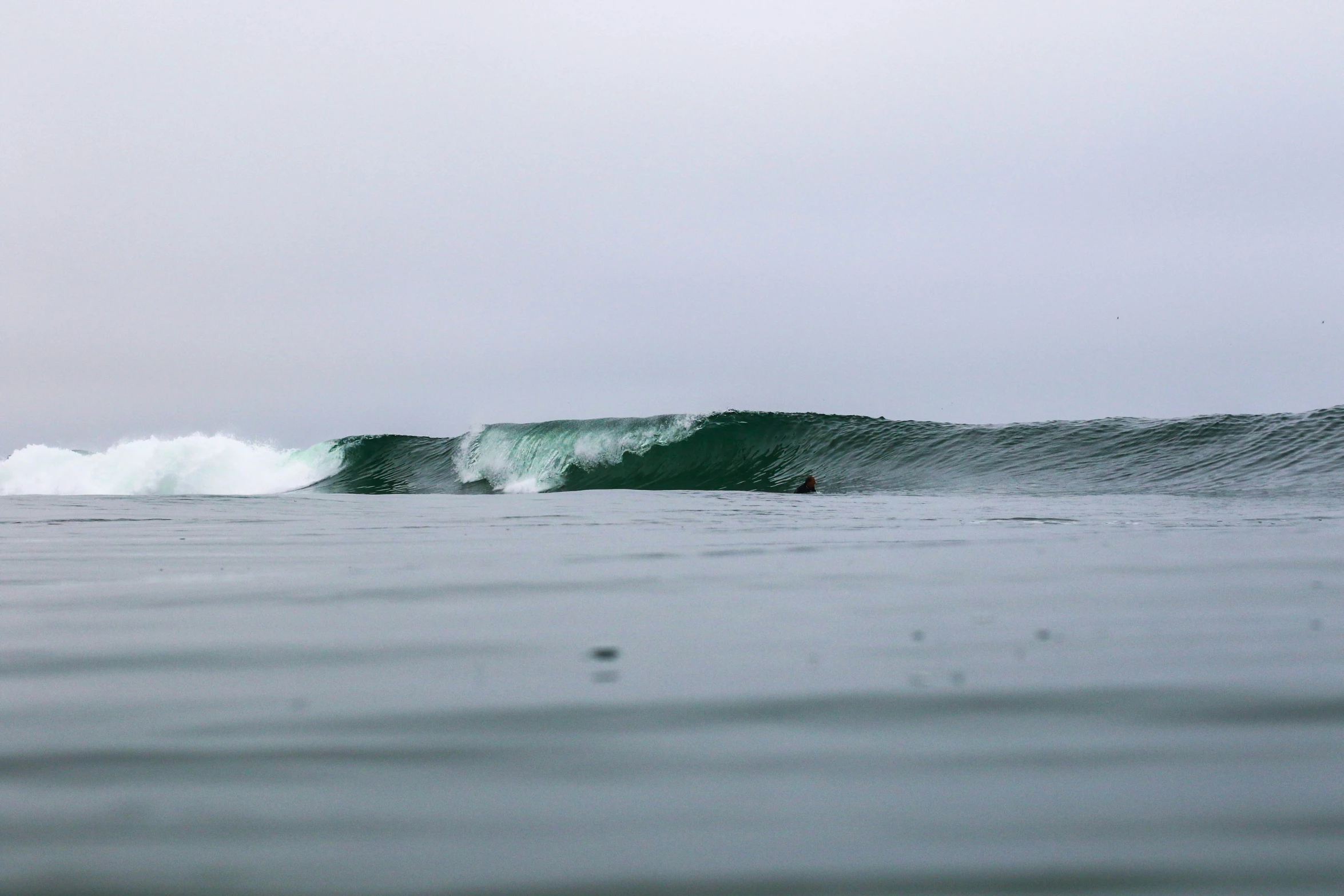 two people ride on the waves in the ocean