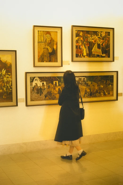 a woman in black is looking at paintings