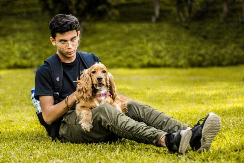 a man and his brown dog sitting in the grass