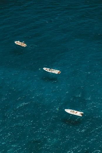 three boats in the ocean near one another