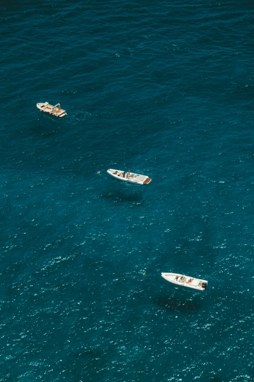 three boats in the ocean near one another