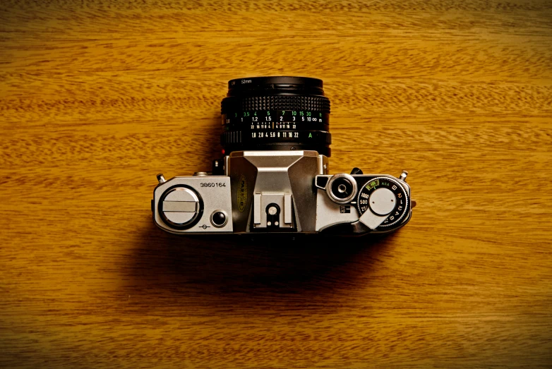 a camera and flash drives sitting on top of a wooden table