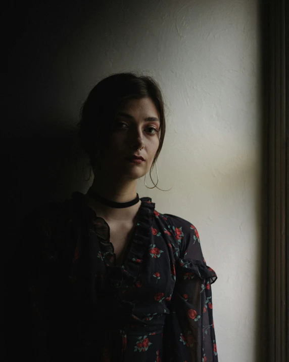 a  in a black floral shirt looking at the camera